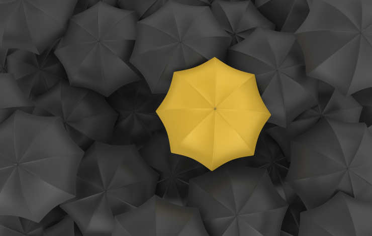 yellow umbrella in a sea of black umbrellas