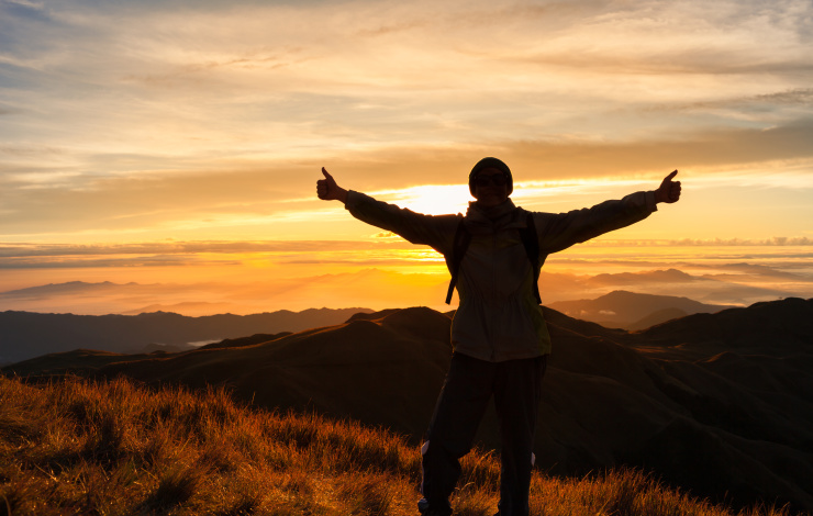man on top of mountain at sunset