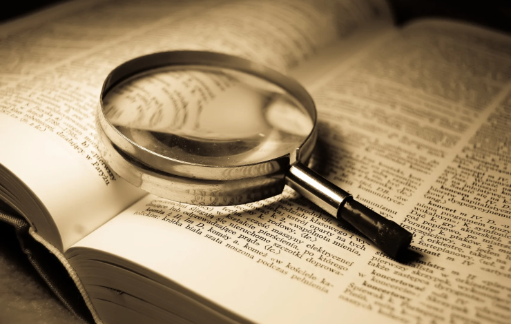 magnifying glass sitting on large case study book