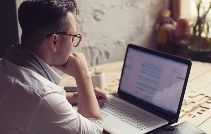 A man reading his email on a laptop computer.