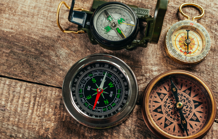 Various compasses on a wooden deck