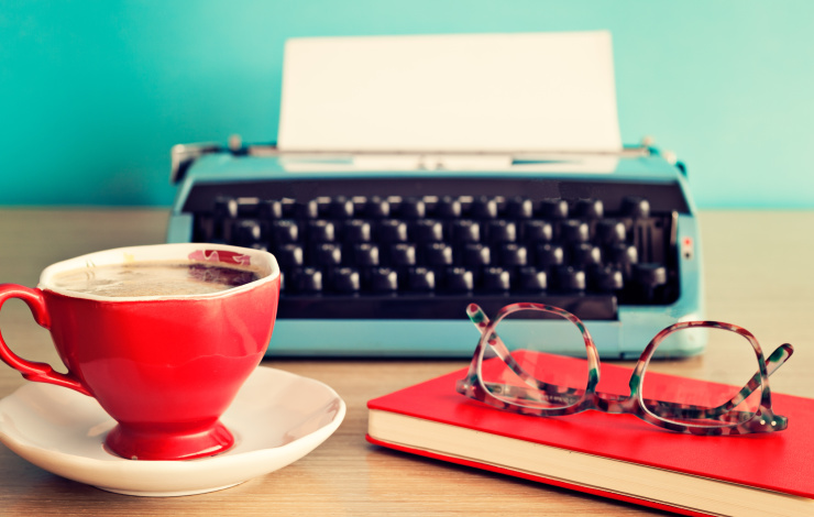 Typewriter on desk with coffee and glasses