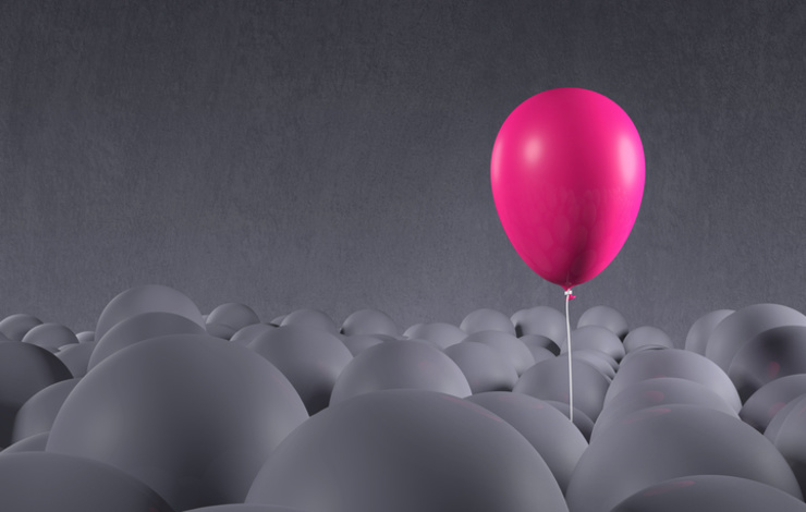pink balloon floating above gray balloons
