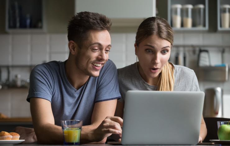 Happy couple in front of laptop