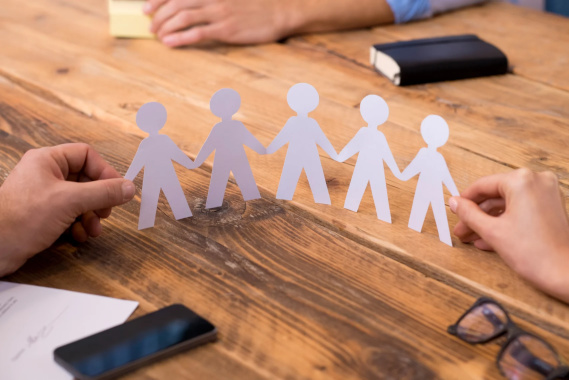 paper dolls connected on a wooden desk