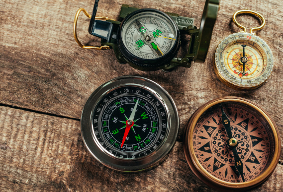 Various compasses on a wooden deck