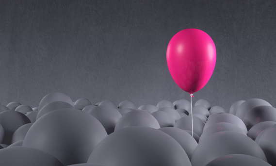pink balloon floating above gray balloons