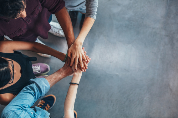 group of people putting their hands in