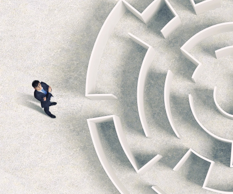 business man standing at the entrance to a maze