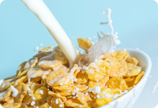 Picture of milk pouring and splashing into a bowl of cereal.