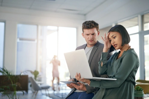 Man and women looking at a computer screen upset