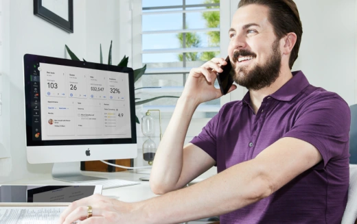 Picture of a Keap user on phone at their desk.