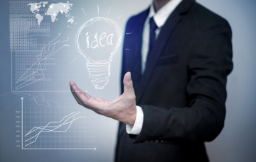 entrepreneur holding an idea lightbulb with graphs
