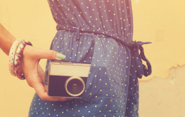 hipster girl holding an old camera with instagram filter