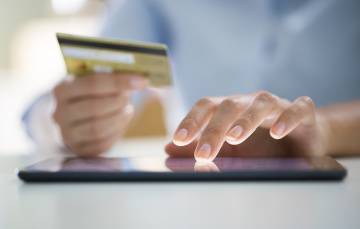 woman shopping online with credit card out and ready to buy