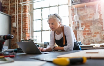 Older woman in workshop on a laptop