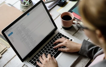 Woman sending email from laptop