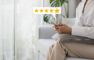 Someone typing on their phone with a 5 star review graphic