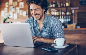 Man smiling looking at a laptop screen