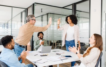 Room full of people with two people giving each other a high five