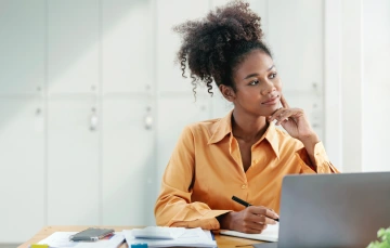 A woman at her desk thinking about something