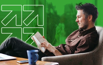 A man sitting in a chair reading a book