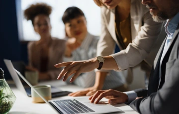 A business team working together in front of a laptop.
