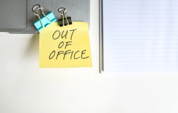 A post-it note placed on a board that says 'Out Of Office'