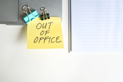 A post-it note placed on a board that says 'Out Of Office'
