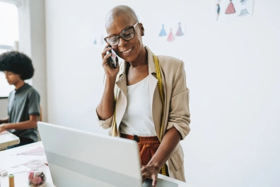 A business woman in the fashion industry standing while talking on the phone, representing how missed calls can be converted into revenue using marketing automation.
