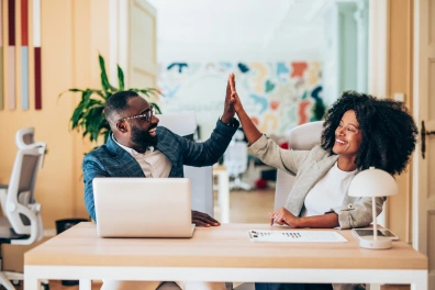 Illustration of two people high fiving in celebration, symbolizing teamwork and successful lead generation.
