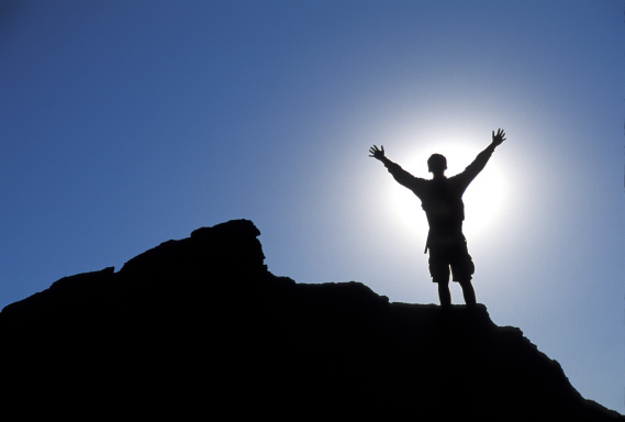 man standing on top of a mountain celebrating success