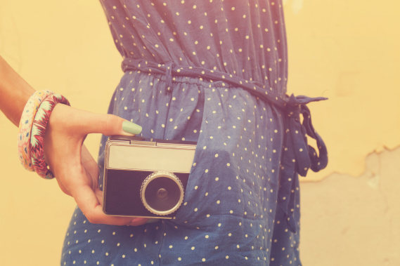 hipster girl holding an old camera with instagram filter