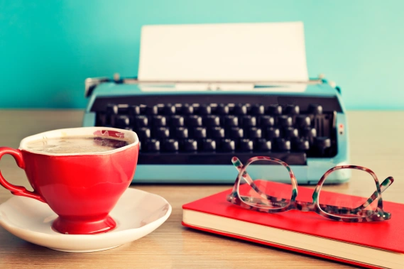 Typewriter on desk with coffee and glasses