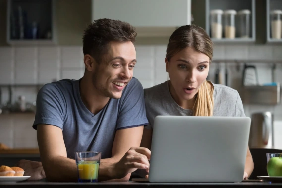 Happy couple in front of laptop