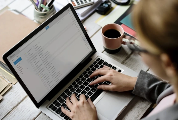 Woman sending email from laptop