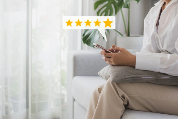 Someone typing on their phone with a 5 star review graphic