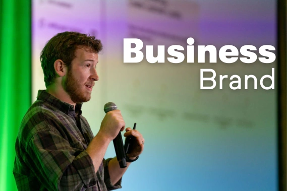 Man from Keap with microphone talking on stage with the words Business Brand next to him