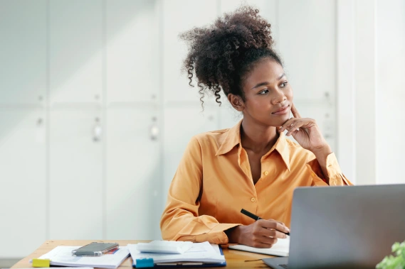 A woman at her desk thinking about something