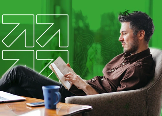 A man sitting in a chair reading a book