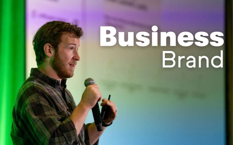 Man from Keap with microphone talking on stage with the words Business Brand next to him